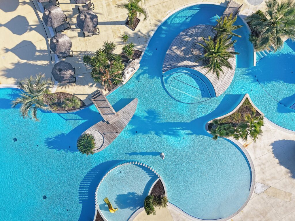 Vue aérienne du grand bassin paysager du parc aquatique du camping 5 étoiles Les Champs Blancs